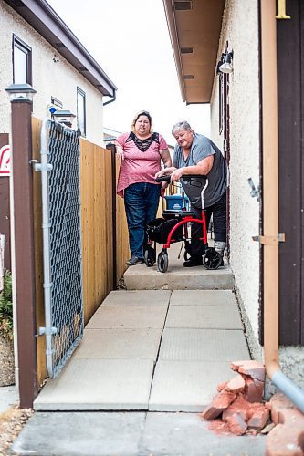 MIKAELA MACKENZIE / WINNIPEG FREE PRESS

Darcie Luzny (left) and her mom Lois Coulson pose for a photo by the troublesome step Lois needs to navigate with her walker to get in and out of the house in Winnipeg on Thursday, April 13, 2023. The provincial government recently announced $1.5 million in funding for retrofits like ramps and walk-in showers. For Malak story.

Winnipeg Free Press 2023.