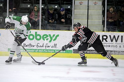Virden Oil Capitals forward Davis Chorney swipes the puck away from Portage Terriers defenceman Tayem Gislason during Game 7 of their Manitoba Junior Hockey League semifinal series at Stride Place on Wednesday night. (Lucas Punkari/The Brandon Sun)
