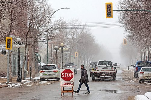 20042023
A pedestrian crosses Rosser Avenue at 7th Street in downtown Brandon near a sign warning motorists that the traffic lights are out during a power outage on Thursday that left a portion of downtown Brandon without power for much of the day.
(Tim Smith/The Brandon Sun)
