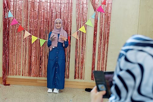 Miriam Masri poses for photos in front of colourful decorations at an Eid al-Fitr celebration in Brandon on Friday. (Tim Smith/The Brandon Sun)