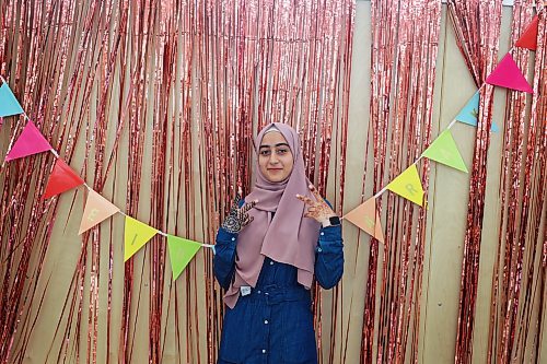 Miriam Masri poses for photos in front of colourful decorations at an Eid al-Fitr celebration in Brandon on Friday. (Tim Smith/The Brandon Sun)