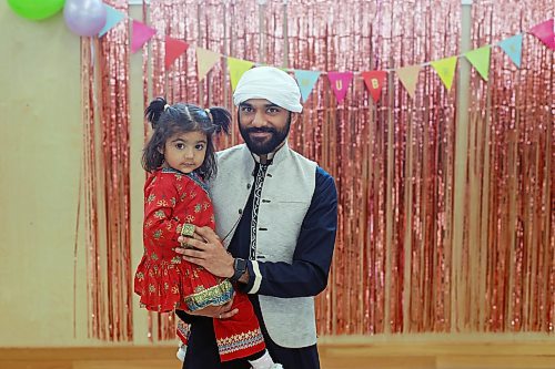 Omer Sajjad holds his niece, Arwa Khan, while socializing at an Eid al-Fitr celebration in Brandon on Friday. (Tim Smith/The Brandon Sun)