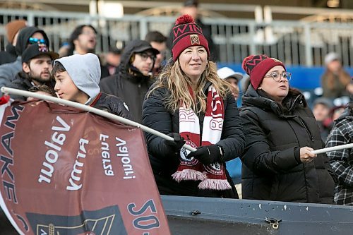 BROOK JONES / WINNIPEG FREE PRESS
Valour FC fan Pola Imaz (middle) waves a Valour Army flag while cheering on the home team at IG field in Winnipeg, Man., Saturday, April 22, 2023. Valour FC played to a 1-1 draw against Athl&#xe9;tico Ottawa. 