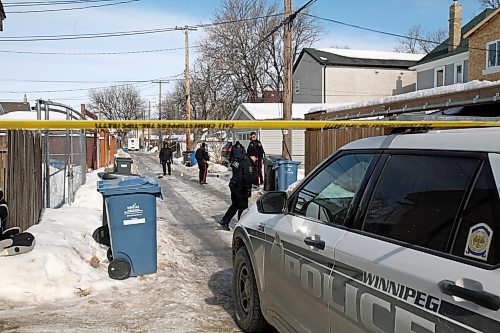 Winnipeg police forensics investigators and other officers work in the lane of Beverley and Toronto streets, between Ellice and St. Matthews avenues, on Tuesday. Two women were found with gunshot wounds at about 6 a.m.; one had died by the time police arrived. ERIK PINDERA/WINNIPEG FREE PRESS