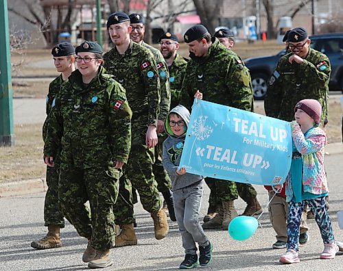 Quinn Hart (right) and Albert (last name unavailable) carry a sign during a support walk at the Teal Up for Military Kids event at CFB Shilo on Thursday. The event, which celebrates the resiliency of military kids, got its start in Shilo and has spread across the country. (Ian Hitchen/Brandon Sun).