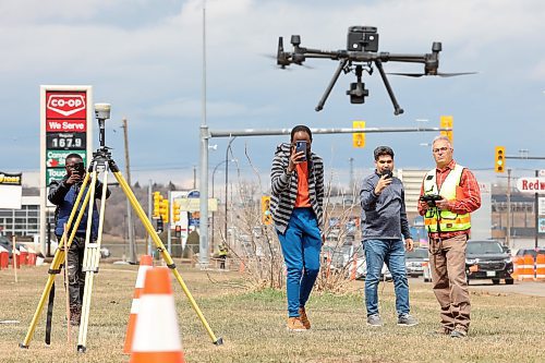 Mario Machado (right), a surveyor with Dillon Consulting, lands a drone while second-year civil technology program students from Assiniboine Community College take photos next to 18th Street North. (Tim Smith/The Brandon Sun)