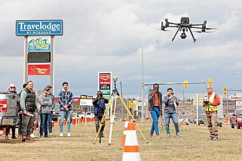 27042023
Mario Machado (R), a surveyor with Dillon Consulting, lands a drone while second year Civil Technology program students from Assiniboine Community College watch next to 18th Street North. Machado spoke to the class about new surveying technology including the use of drones during a field trip by the class to the Daly Overpass replacement project on Thursday.  (Tim Smith/The Brandon Sun)