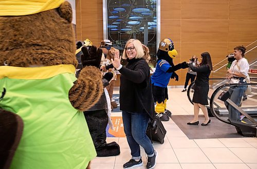 JESSICA LEE / WINNIPEG FREE PRESS

Lisa Roughly high-fives Manitoba&#x2019;s tourism and recreation mascots after stepping off of her flight at Winnipeg&#x2019;s Richardson Airport April 28, 2023. The mascots were there to celebrate tourism week in Canada.

Stand up