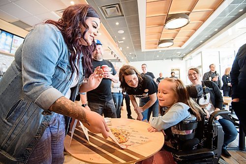 Mike Sudoma / Winnipeg Free Press
Smile Cookie Ambassador Braelynn Bodman judges Kirby of 92.1 Citi FM’s cookie decorating handiwork during a contest Monday
May 1, 2023