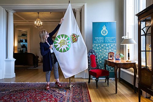 RUTH BONNEVILLE / WINNIPEG FREE PRESS 

Local - Coronation Flag

Kate Gameiro &#x1805;xecutive Director of the Lieutenant Governor of Manitoba, adjusts the new Coronation Flag at Manitoba House Wednesday. 

See story. 
May 3rd,, 2023