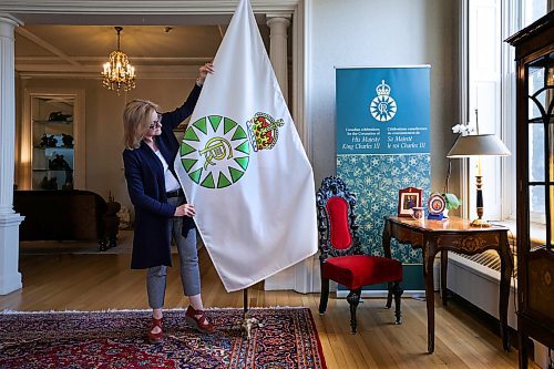 RUTH BONNEVILLE / WINNIPEG FREE PRESS 

Local - Coronation Flag

Kate Gameiro &#x1805;xecutive Director of the Lieutenant Governor of Manitoba, adjusts the new Coronation Flag at Manitoba House Wednesday. 

See story. 
May 3rd,, 2023