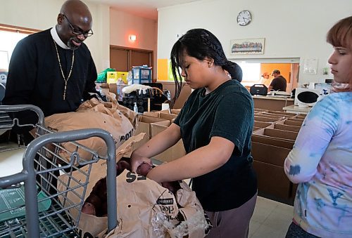 JESSICA LEE / WINNIPEG FREE PRESS

From left to right: Priest Wilson Akinwale, Zara Buenaventura and Daisy Robinson pack potatoes into hampers May 3, 2023 at the kreative Kitchen at St. Thomas Anglican in Weston, where food insecure community members gather to pick up hot meals and a hamper on Wednesday nights.

Reporter: John Longhurst