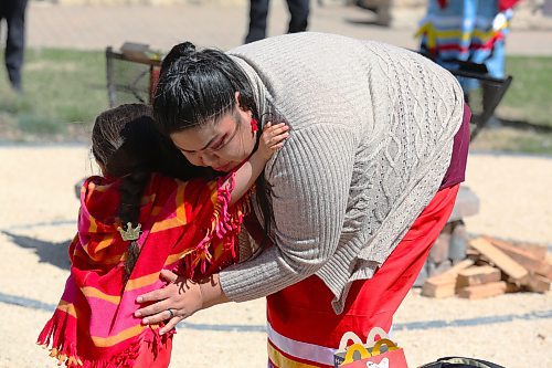 Ashley McKay hugs her three-year-old daughter Alaura during Friday's Red Dress Day ceremony at Brandon University. (Kyle Darbyson/The Brandon Sun)