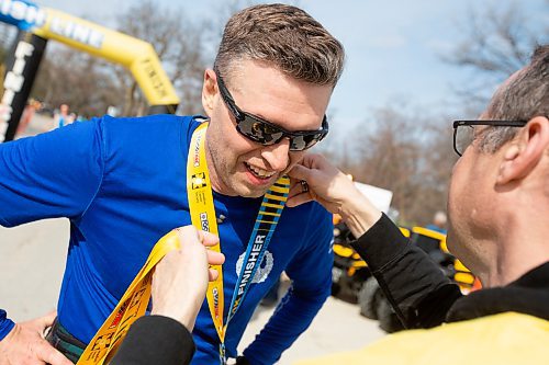 BROOK JONES / WINNIPEG FREE PRESS
Queen's Own Cameron Highlanders of Canada Lt. - Col. Jon Baker receives a finisher medal after crossing the finish line in the Winnipeg Police Service Half Marathon in Winnipeg, Man., Sunday, May 7, 2023.

