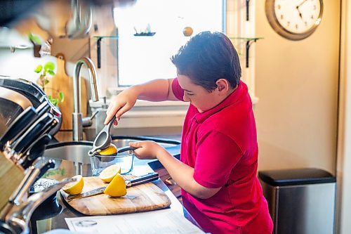 MIKAELA MACKENZIE / WINNIPEG FREE PRESS
 
Jack Taylor, 10, squeezes fresh lemon juice while making lemon curd for mini cheesecakes that he&#x573; planning on making for his mom this mother&#x573; day in Winnipeg on Monday, May 1, 2023. For Eva story.

Winnipeg Free Press 2023.