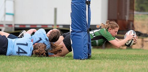 Dauphin Clippers' Bree Walker, right, stretches the ball out for a try against the Rivers Rams during their Westman High School Rugby varsity girls' game at John Reilly Field on Thursday. (Thomas Friesen/The Brandon Sun)