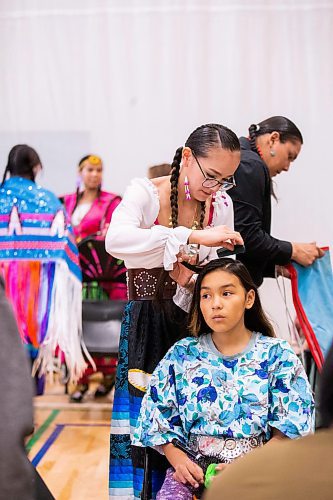 MIKAELA MACKENZIE / WINNIPEG FREE PRESS
 
Shyla Boubard helps her cousin, Lillee Hotomani (11), with putting her hair into braids for the RETSD Powwow at Collge Miles Macdonell Collegiate in Winnipeg on Thursday, May 11, 2023. Standup.

Winnipeg Free Press 2023.