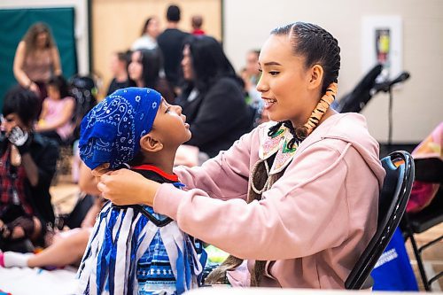 MIKAELA MACKENZIE / WINNIPEG FREE PRESS
 
Cassie Demas helps her little brother, Kyrie Lawson (four), get ready for the RETSD Powwow at Collge Miles Macdonell Collegiate in Winnipeg on Thursday, May 11, 2023. Standup.

Winnipeg Free Press 2023.