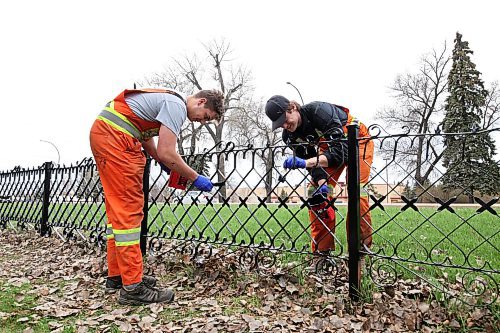 11052023
Colby Carmichael and Liam Kindle with the City of Brandon Parks and Recreation Services work alongside other crew members to repaint the fence that lines the Brandon Cemetery along 18th Street on Friday. Workers spent the week removing rust from the fence and repainting it.
(Tim Smith/The Brandon Sun)
