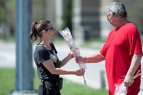 BROOK JONES / WINNIPEG FREE PRESS
A volunteer with Winnipeg Pet Rescue hands Stephanie Hemlow (left) an orchid flower on Mother's Day. The local pet rescue was handing out flowers at no charge and also for donations near the intersection of Pembina Highway and Chancellor Drive in Winnipeg, Man., Sunday, May 14, 2023. 
