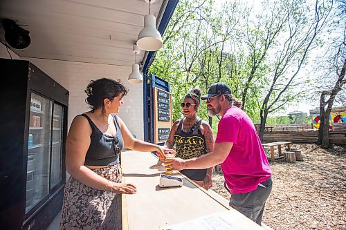 MIKAELA MACKENZIE / WINNIPEG FREE PRESS
 
Manny Davies hands a house lager and a milkshake sour to Rain Gunderson (centre) and Adam (right, no last name given) at The Beer Can on Monday, May 15, 2023. For patio Wasney story.

Winnipeg Free Press 2023.