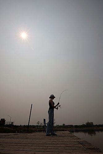 16052023
Phoenix Jackson fishes from the dock on the Assiniboine River at Dinsdale Park on a hot and smokey Tuesday afternoon. Fishing is Jackson&#x2019;s favourite pastime. 
(Tim Smith/The Brandon Sun)