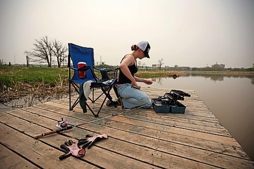 16052023
Phoenix Jackson fishes from the dock on the Assiniboine River at Dinsdale Park on a hot and smokey Tuesday afternoon. Fishing is Jackson&#x2019;s favourite pastime. 
(Tim Smith/The Brandon Sun)