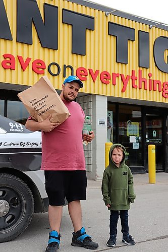 Shawn Sousa with his son Jamison outside the Giant Tiger at 305 McPhillips Street on April 18, 2023. The store was targeted by a pair of shoplifters the night before. (Tyler Searle / Winnipeg Free Press) 