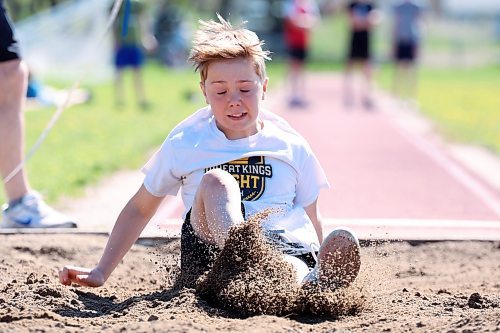 Grade 6 student Callum Wilson kicks up sand while competing in the long jump event during École Harrison’s track and field day at the UCT Stadium on Friday. (Tim Smith/The Brandon Sun)