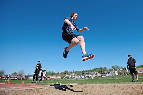 Thomas Seitz, a Grade 8 student from École Harrison, sails through the air while competing in the triple jump event at the school’s track and field day at the UCT Stadium on Friday. (Tim Smith/The Brandon Sun)
