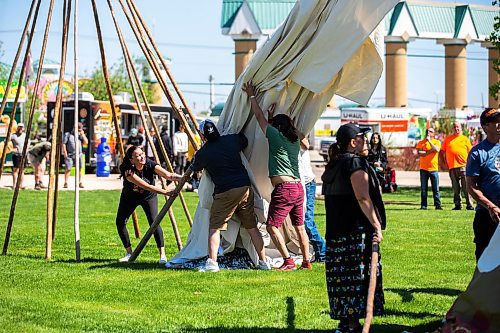 MIKAELA MACKENZIE / WINNIPEG FREE PRESS
 
Rachel Copenace (left), Maurice Meeches, and Christopher N. Courchene race to put up their tipi at the Manito Ahbee Tipi Raising Contest at the Red River Exhibition grounds on Friday, May 19, 2023. 

Winnipeg Free Press 2023.