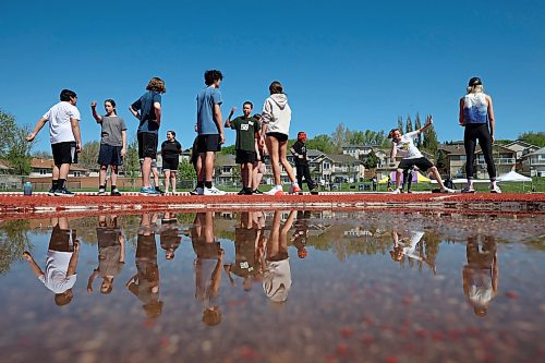 19052023
&#xc9;cole Harrison students are reflected in a puddle while taking turns competing in the shot put event during the school&#x2019;s track and field day at the UCT Stadium on Friday. (Tim Smith/The Brandon Sun)