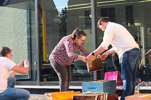 Mike Clark of Clark Apiaries, right, helps Brandon University English professor Deanna Smid, centre, and director of communications Grant Hamilton, left, install a pair of beehives on campus this past Saturday morning. The installation of these hives marks the beginning of this year's urban beekeeping project known as "Bee U." Clark, Smid and Hamilton are hoping to set up a total of four hives on the roof of the Knowles-Douglas Student Union Building this summer. (Kyle Darbyson/The Brandon Sun)