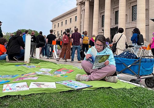 Maggie Macintosh / Winnipeg Free Press
Grade 3 student Margot McNabb reads a picture book at a Winnipeg rally in solidarity with opponents of book bans. 
