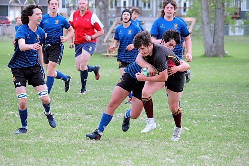 Liam Southcombe of the Crocus Plainsmen powers through a tackle attempt from George Vorster of the Souris Sabres during a Westman High School Rugby varsity boys semifinal game on Tuesday evening. (Lucas Punkari/The Brandon Sun)