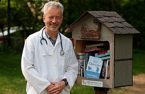 JOHN WOODS / WINNIPEG FREE PRESS
Philipp Schott, local author and veterinarian, is photographed with his new mystery novel, Six Ostriches, at his book exchange outside his home Tuesday, May 23, 2023. 

Reporter: sigurdson