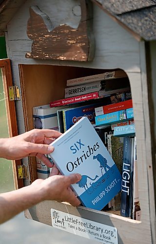 JOHN WOODS / WINNIPEG FREE PRESS
Philipp Schott, local author and veterinarian, is photographed with his new mystery novel, Six Ostriches, at his book exchange outside his home Tuesday, May 23, 2023. 

Reporter: sigurdson