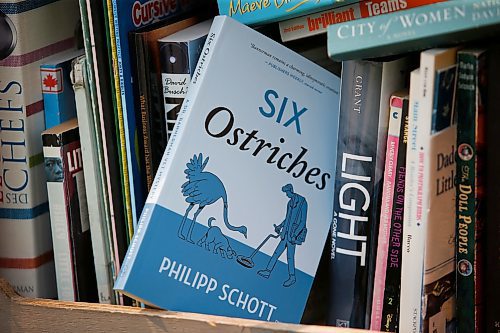 JOHN WOODS / WINNIPEG FREE PRESS
Philipp Schott, local author and veterinarian, is photographed with his new mystery novel, Six Ostriches, at his book exchange outside his home Tuesday, May 23, 2023. 

Reporter: sigurdson