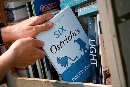 JOHN WOODS / WINNIPEG FREE PRESS
Philipp Schott, local author and veterinarian, is photographed with his new mystery novel, Six Ostriches, at his book exchange outside his home Tuesday, May 23, 2023. 

Reporter: sigurdson