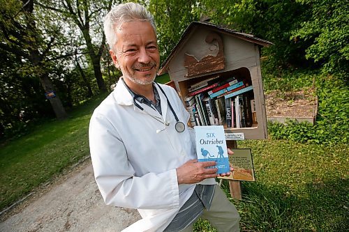 JOHN WOODS / WINNIPEG FREE PRESS
Philipp Schott, local author and veterinarian, is photographed with his new mystery novel, Six Ostriches, at his book exchange outside his home Tuesday, May 23, 2023. 

Reporter: sigurdson