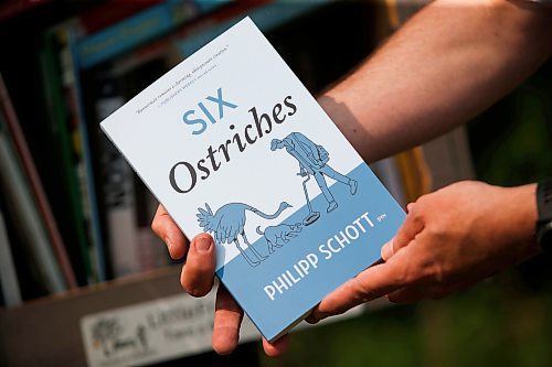 JOHN WOODS / WINNIPEG FREE PRESS
Philipp Schott, local author and veterinarian, is photographed with his new mystery novel, Six Ostriches, at his book exchange outside his home Tuesday, May 23, 2023. 

Reporter: sigurdson