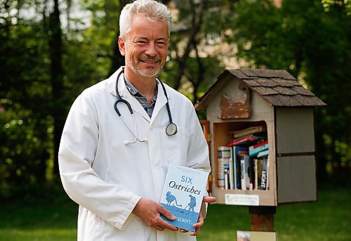 JOHN WOODS / WINNIPEG FREE PRESS
Philipp Schott, local author and veterinarian, is photographed with his new mystery novel, Six Ostriches, at his book exchange outside his home Tuesday, May 23, 2023. 

Reporter: sigurdson