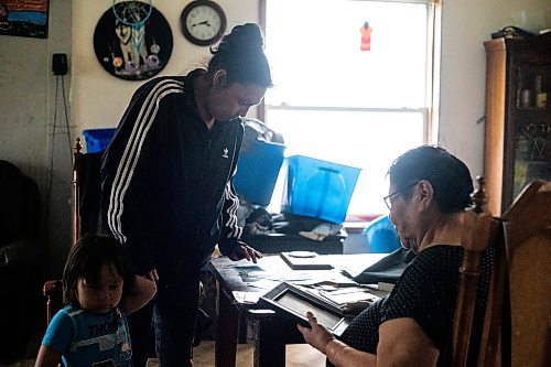 MIKAELA MACKENZIE / WINNIPEG FREE PRESS
 
 Janet Bruyere, grandmother of Fonassa Bruyere (whose body was discovered in a field northwest Winnipeg in 2007), looks through old family photos of Fonassa with her granddaughter, Crystal McLean, and great-grandson, Christian Sinclair (three), at her home on Sagkeeng First Nation on Tuesday, May 23, 2023. For Shelley story.

Winnipeg Free Press 2023.