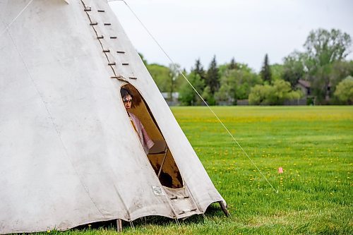 Mike Deal / Winnipeg Free Press
Natalie Brightnose Mousseau, 9, watches from inside a teepee during the Treaty One Nation Land Reclamation Ceremony for the Naawi-Oodena Treaty One Jointly Held lands, on the former Kapyong Barracks lands in Winnipeg, Wednesday morning.
230524 - Wednesday, May 24, 2023.