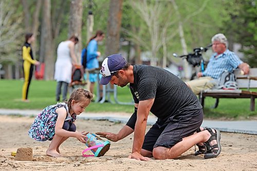 Pierre Tetrault and his four-year-old daughter, Celeste, play in the sand at the beach in Wasagaming on a warm Thursday afternoon. (Tim Smith/The Brandon Sun)