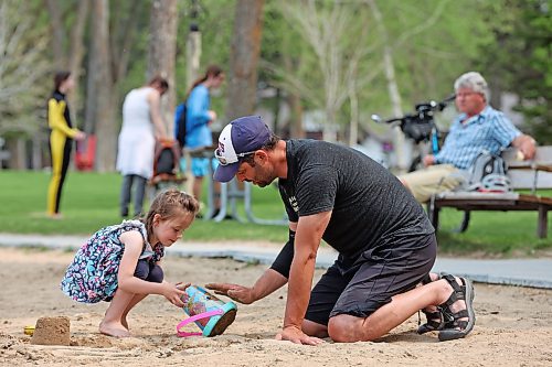 25052023
Pierre Tetrault and his daughter Celeste, four, play in the sand together at the beach in Wasagaming on a hot Thursday afternoon. 
(Tim Smith/The Brandon Sun)