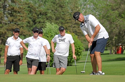 Jason Falk, right, putts while Team Crane looks on during their five-on-five match at Wheat City Golf Course on Friday. (Thomas Friesen/The Brandon Sun)