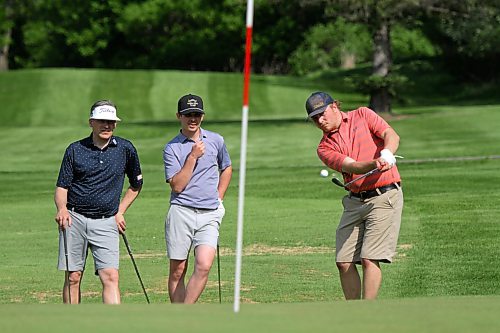 Wheat City superintendent Colton Willms chips in for birdie on the 14th hole while Dave Scinocca, left, and Jordan Kaspick watch. (Thomas Friesen/The Brandon Sun)