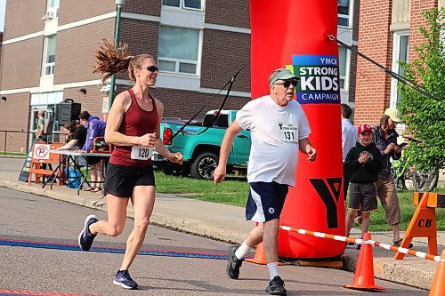 Jill Gray and Wayne Lees cross the finish line at this year's YMCA Strong Kids Run in Brandon. Gray and Lees completed the 5K portion of the event. (Kyle Darbyson/The Brandon Sun)