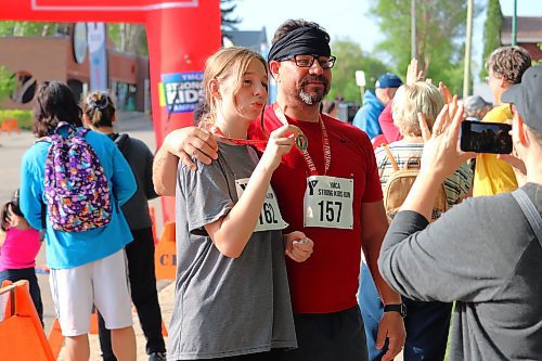 Sophie and Bryan Martin show off their hardware after completing the 5K portion of this year's YMCA Strong Kids Run in Brandon. (Kyle Darbyson/The Brandon Sun)